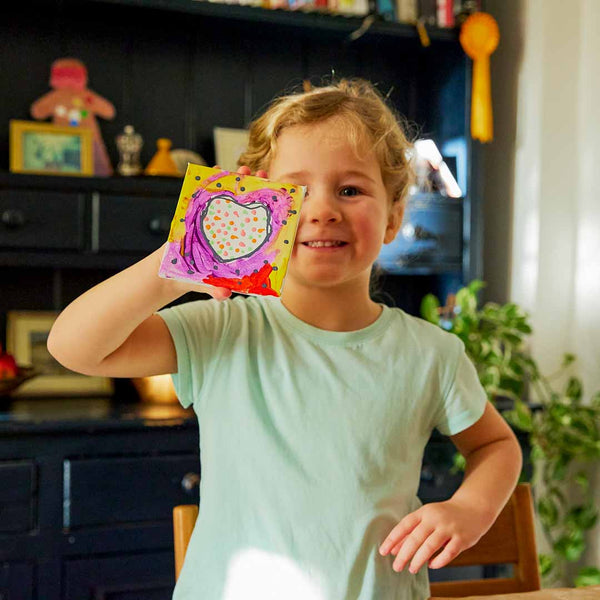 Girl holding her finished Sculpd canvas painting in front of her