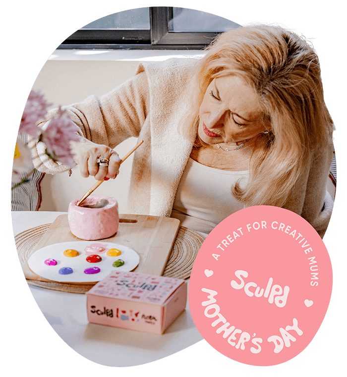 Woman paints a clay piece with Sculpd Acrylic Paint Set and tools from Sculpd Pottery Kit